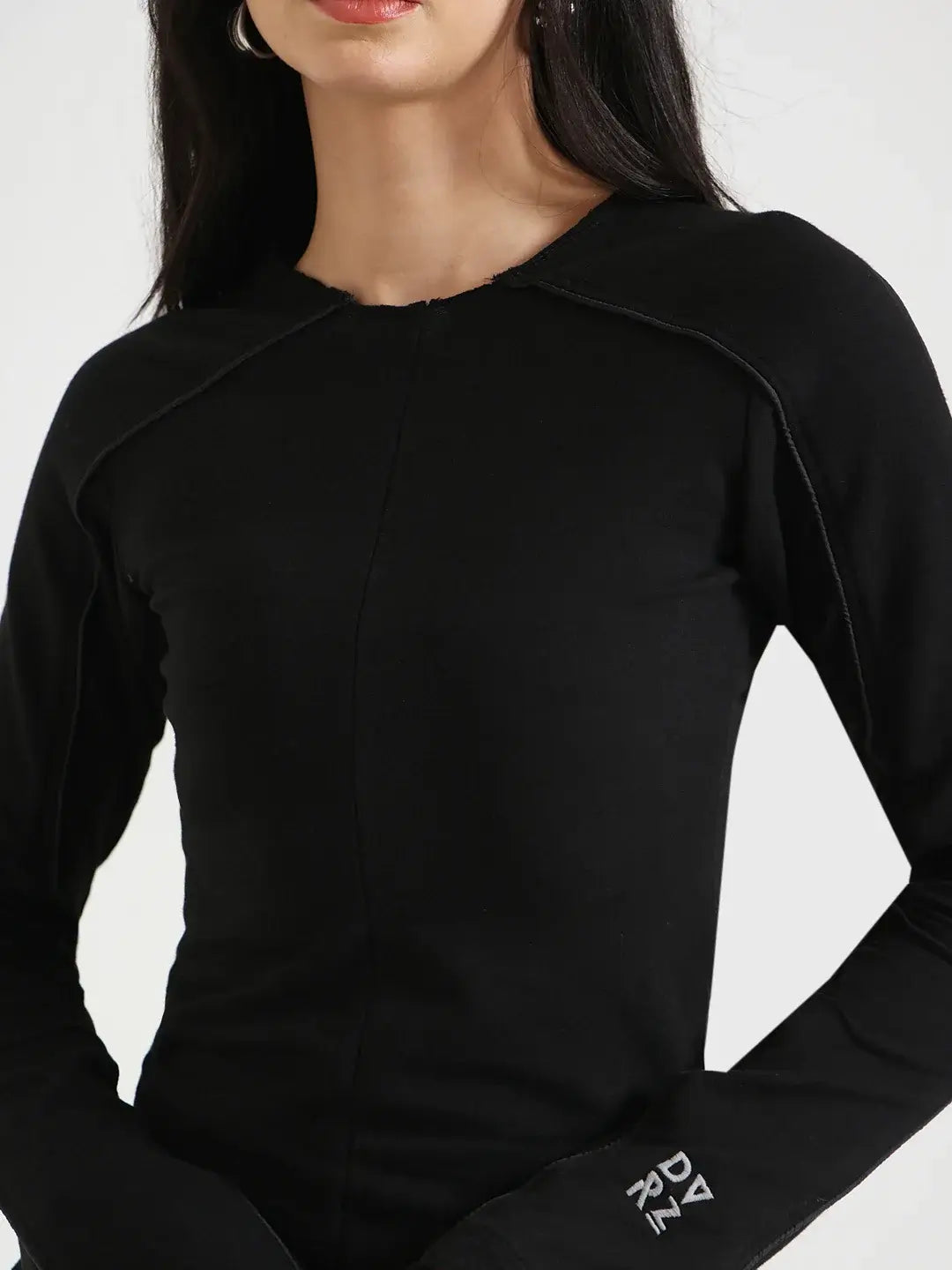 Zoomed in image of a woman wearing a black Flared Long Sleeve Top against a neutral background