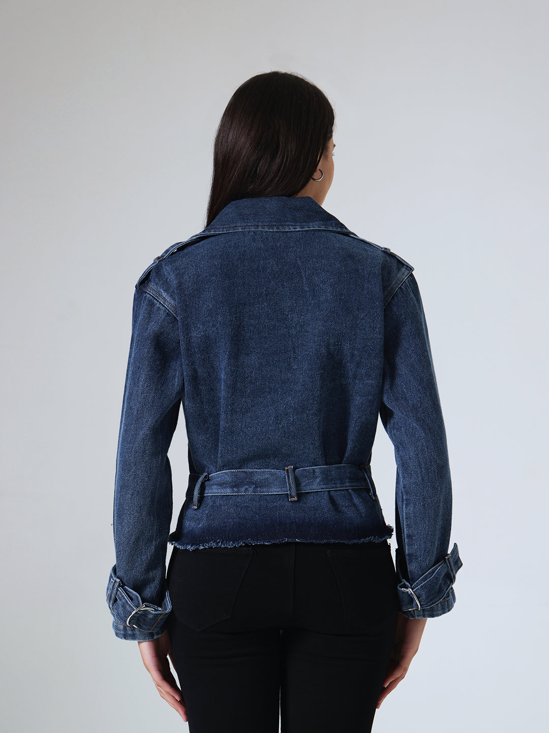 Person wearing a blue denim jacket against a plain background