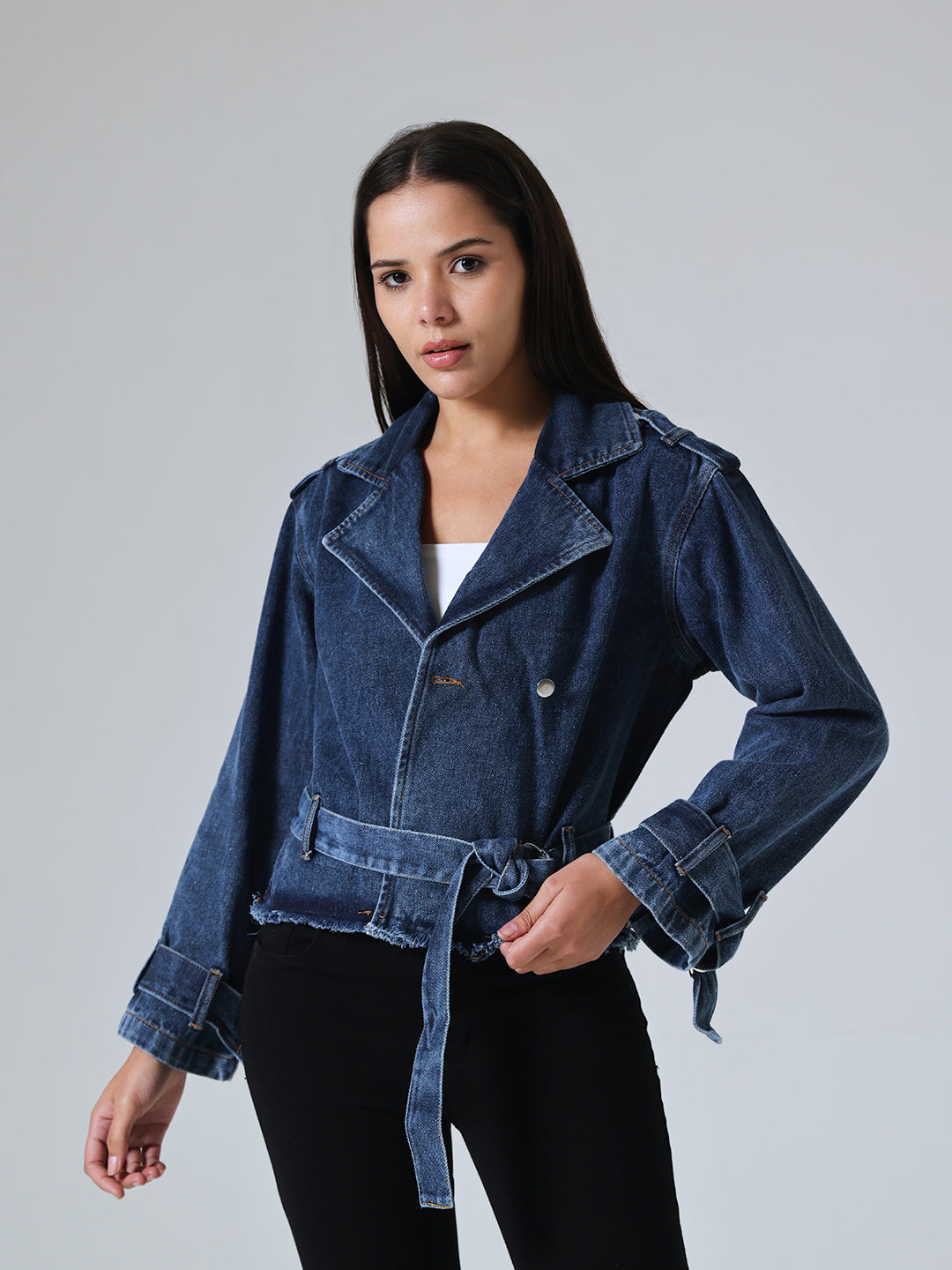 Woman wearing a blue denim jacket against a gray background