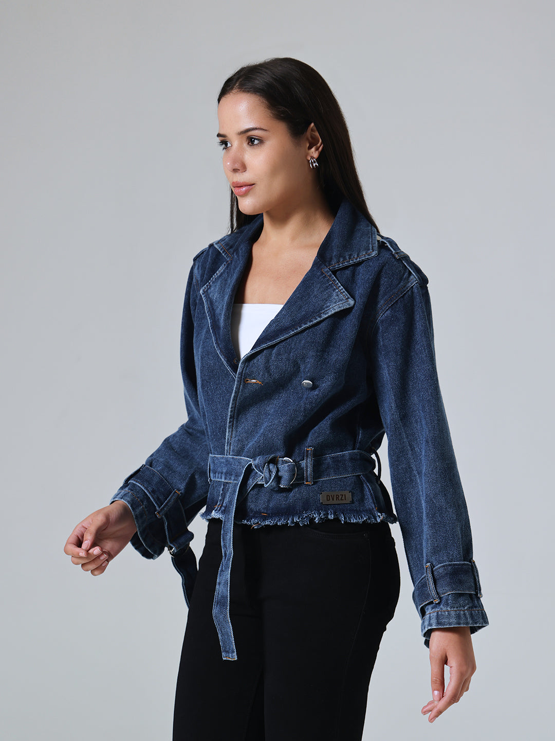 Woman wearing Dvrzi's blue denim biker jacket on a gray background