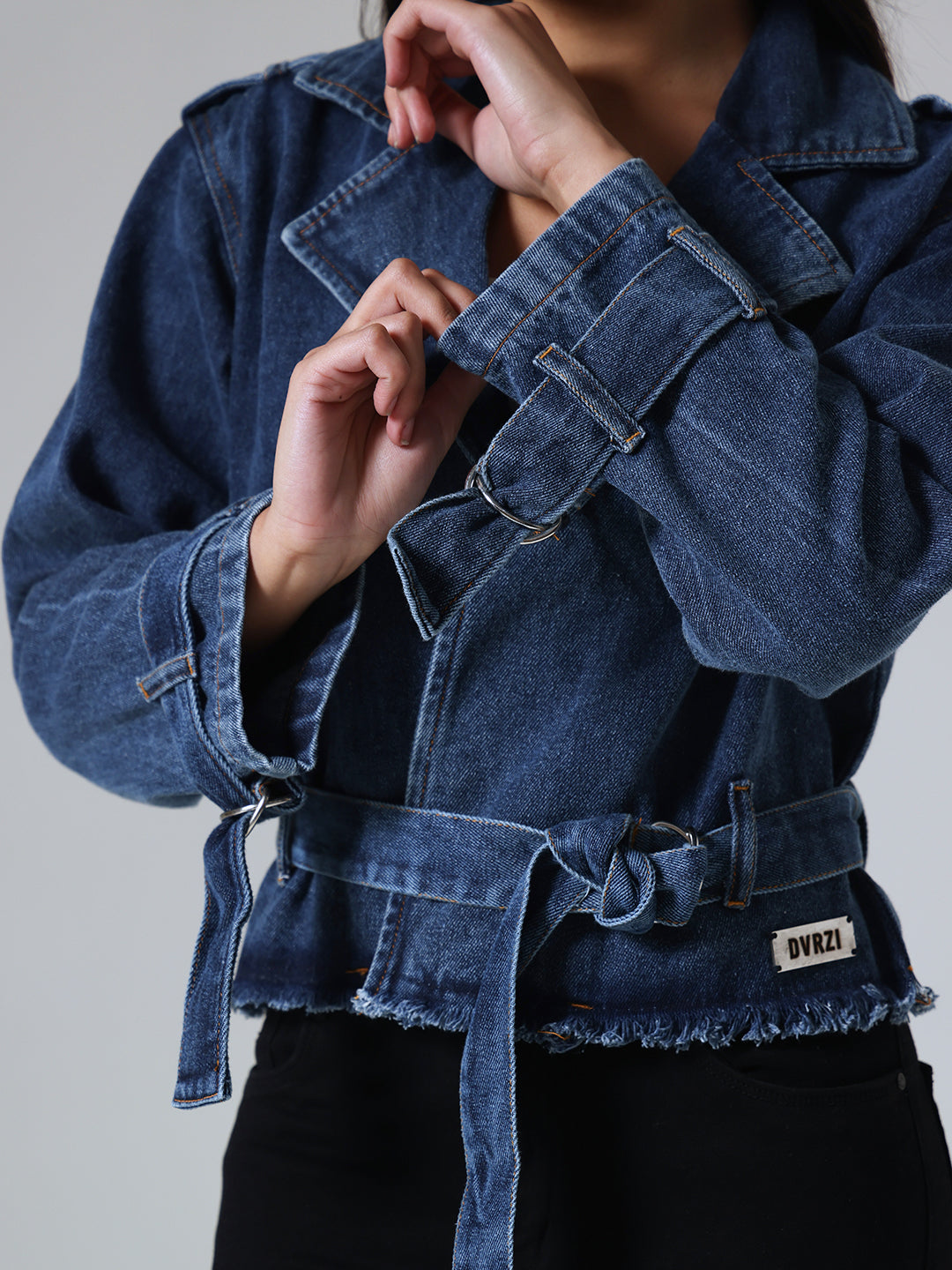 Blue denim jacket with a belt, brand visible, on a neutral background